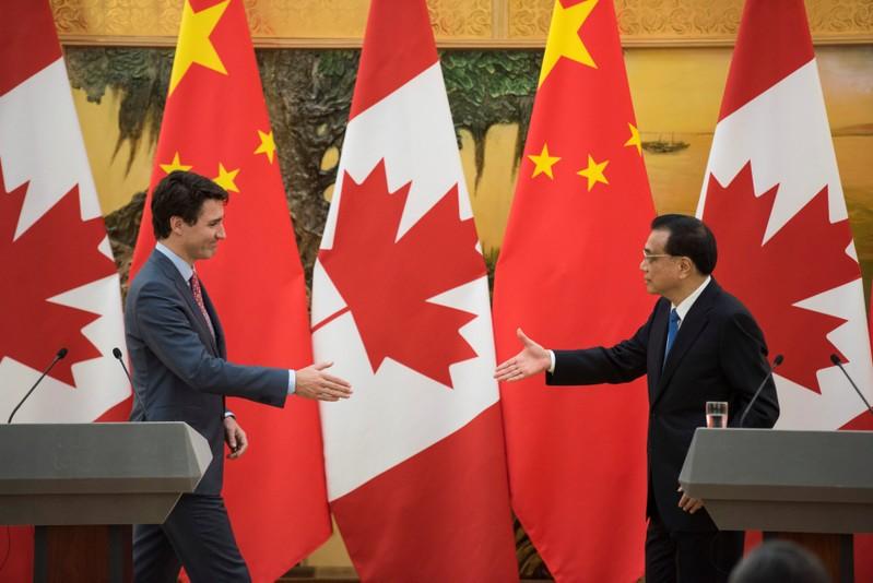 Canadian Prime Minister Justin Trudeau and Chinese Premier Li Keqiang reach out to shake hands during a news conference meeting at the Great Hall of the People in Beijing, China . REUTERS/Fred Dufour/Pool