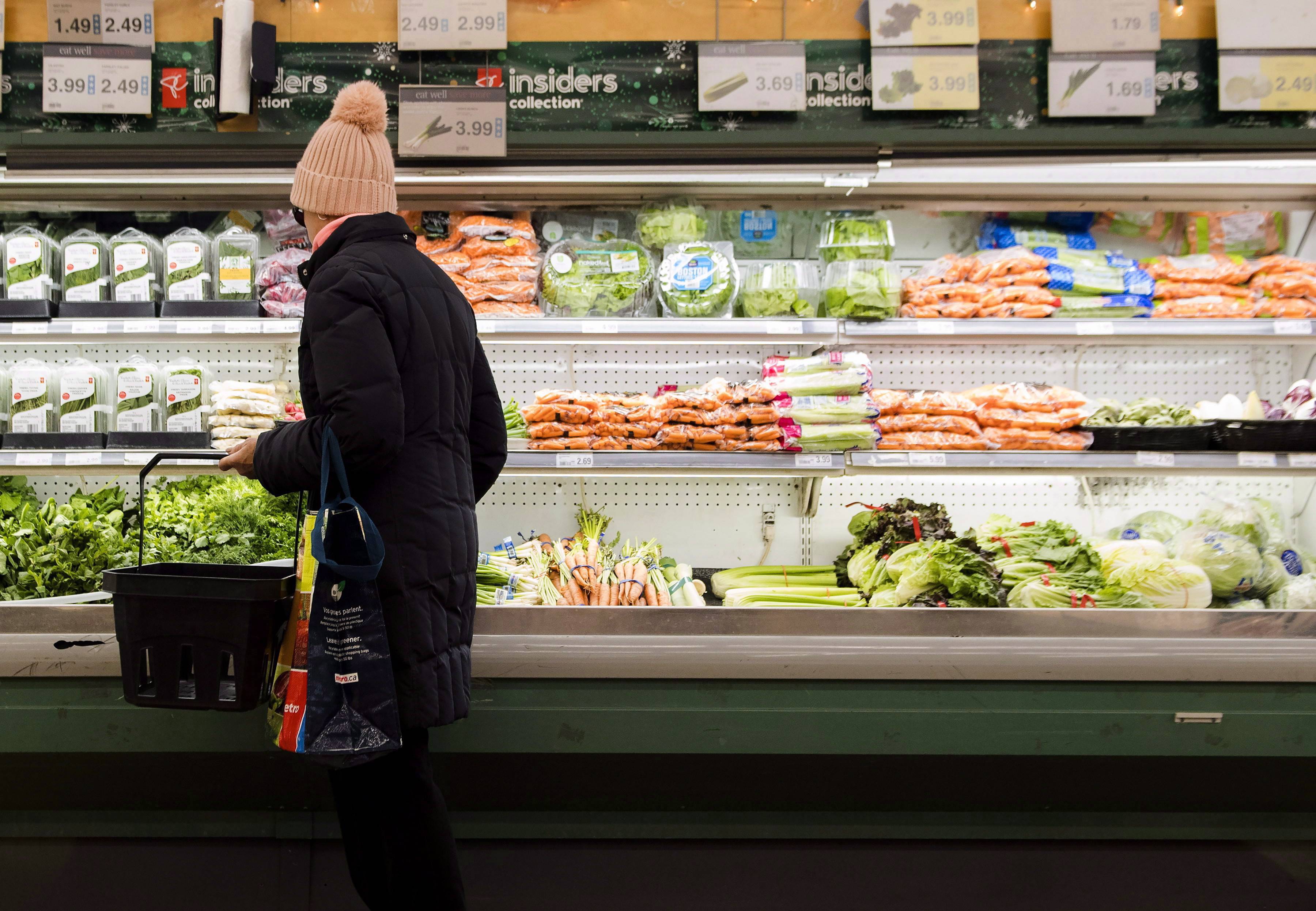 A women overlooks produce in a grocery store in Toronto - THE CANADIAN PRESS/Nathan Denette