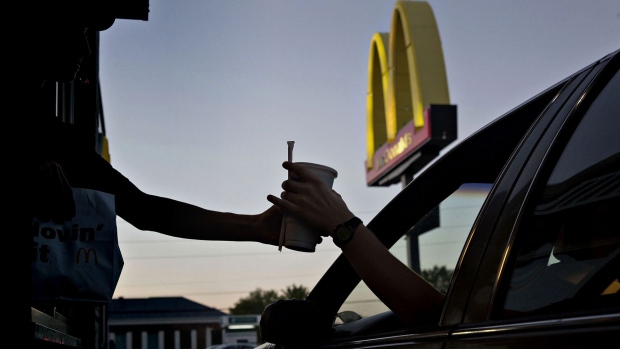 An employee hands a beverage to a customer at the drive-thru window of a McDonald's Corp. restaurant in Peru, Illinois. Photographer: Daniel Acker/Bloomberg , Photographer: Daniel Acker/Bloomberg