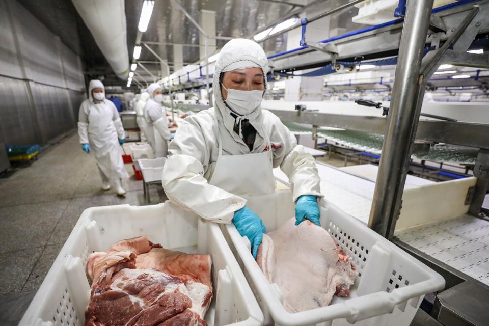 Workers processing pork at a food factory in China this month. AFP VIA GETTY IMAGES