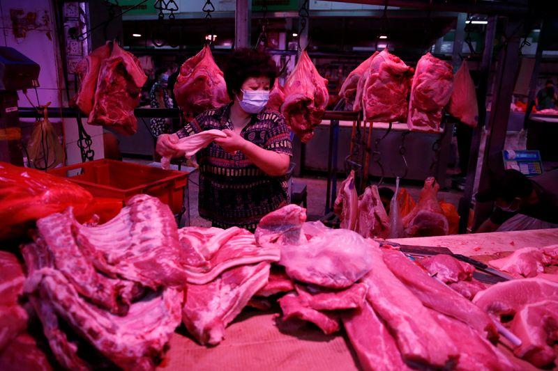 A vendor wearing a face mask prepares pork meat inside the Yuegezhuang wholesale market, following new cases of coronavirus disease (COVID-19) infections in Beijing, China June 17, 2020. REUTERS/Tingshu Wang