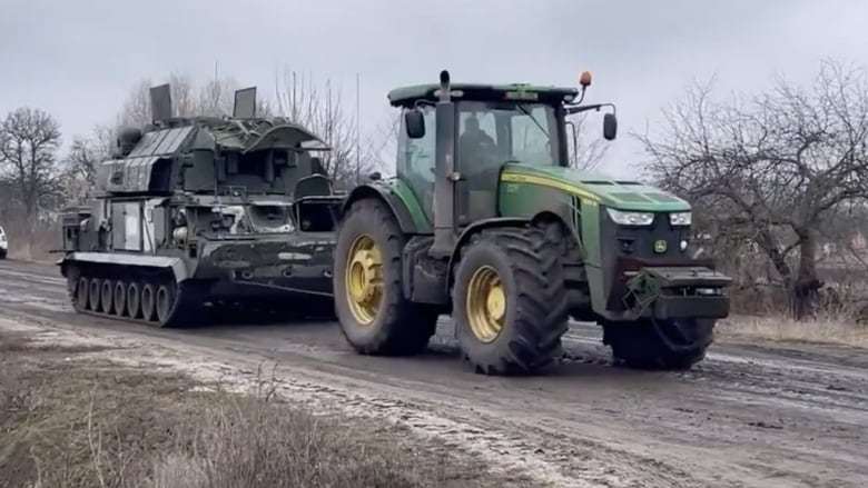 In what has become a recurring theme on the internet during the war in Ukraine, a tractor tows an abandoned Russian vehicle in southern Ukraine. (RALee85/Twitter)