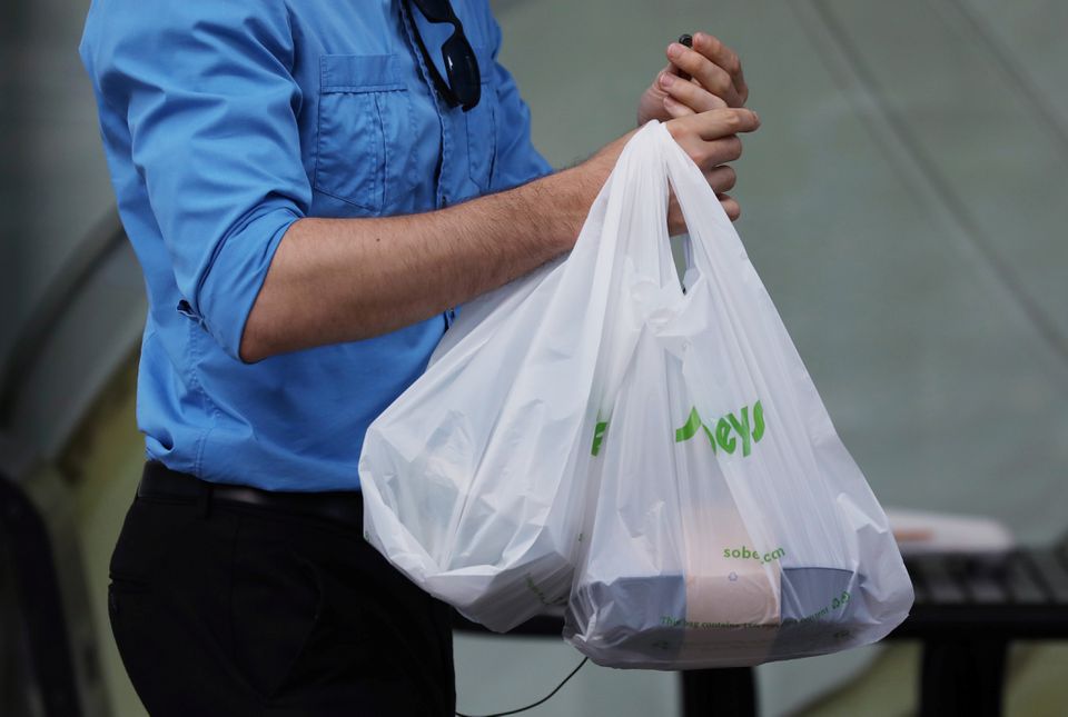 A customer leaves a Sobeys grocery store carrying plastic bags in Ottawa, Ontario, Canada, July 31, 2019. REUTERS/Chris Wattie