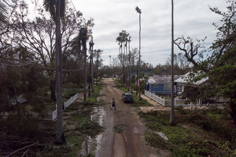 A man walks in a street amid debris after Hurricane Ian caused widespread destruction, in Fort Myers, Florida, U.S., September 29, 2022. REUTERS/Marco Bello
