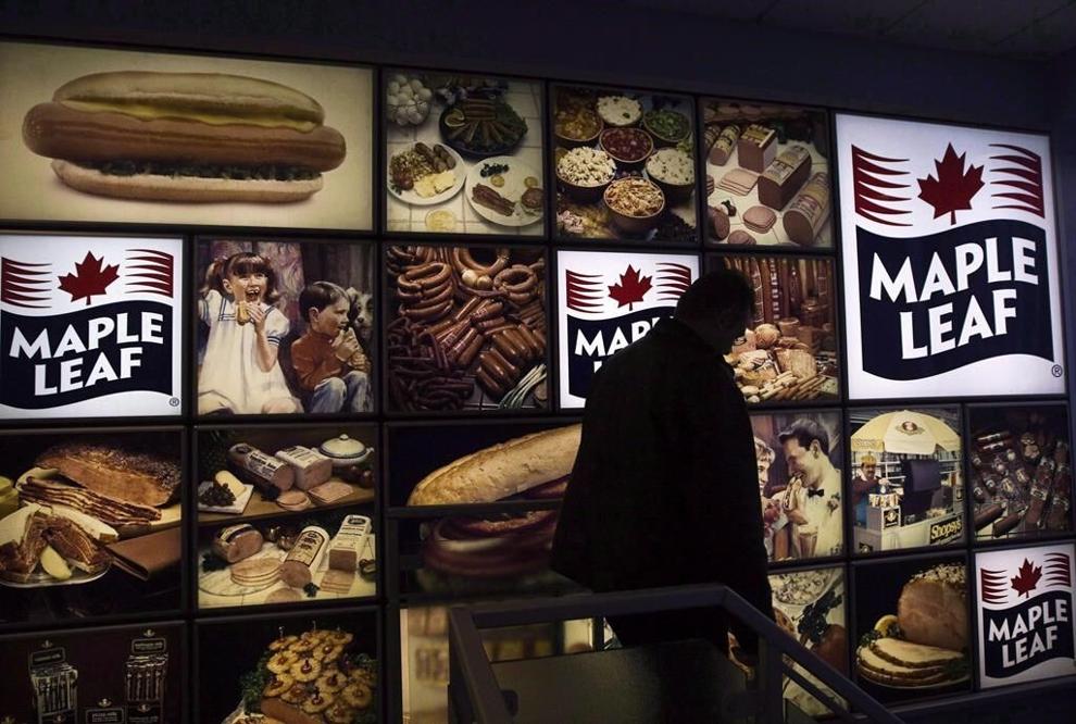 A Maple Leaf Foods employee walks past a Maple Leaf sign at the company's meat facility in Toronto on Monday, December, 15, 2008. THE CANADIAN PRESS/Nathan Denette