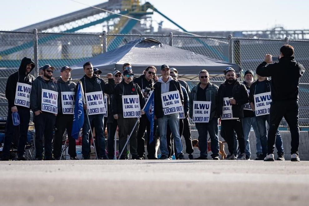 Workers pose for a photo while picketing at Neptune Terminal during an International Longshore and Warehouse Union labour dispute in North Vancouver - THE CANADIAN PRESS/Ethan Cairns